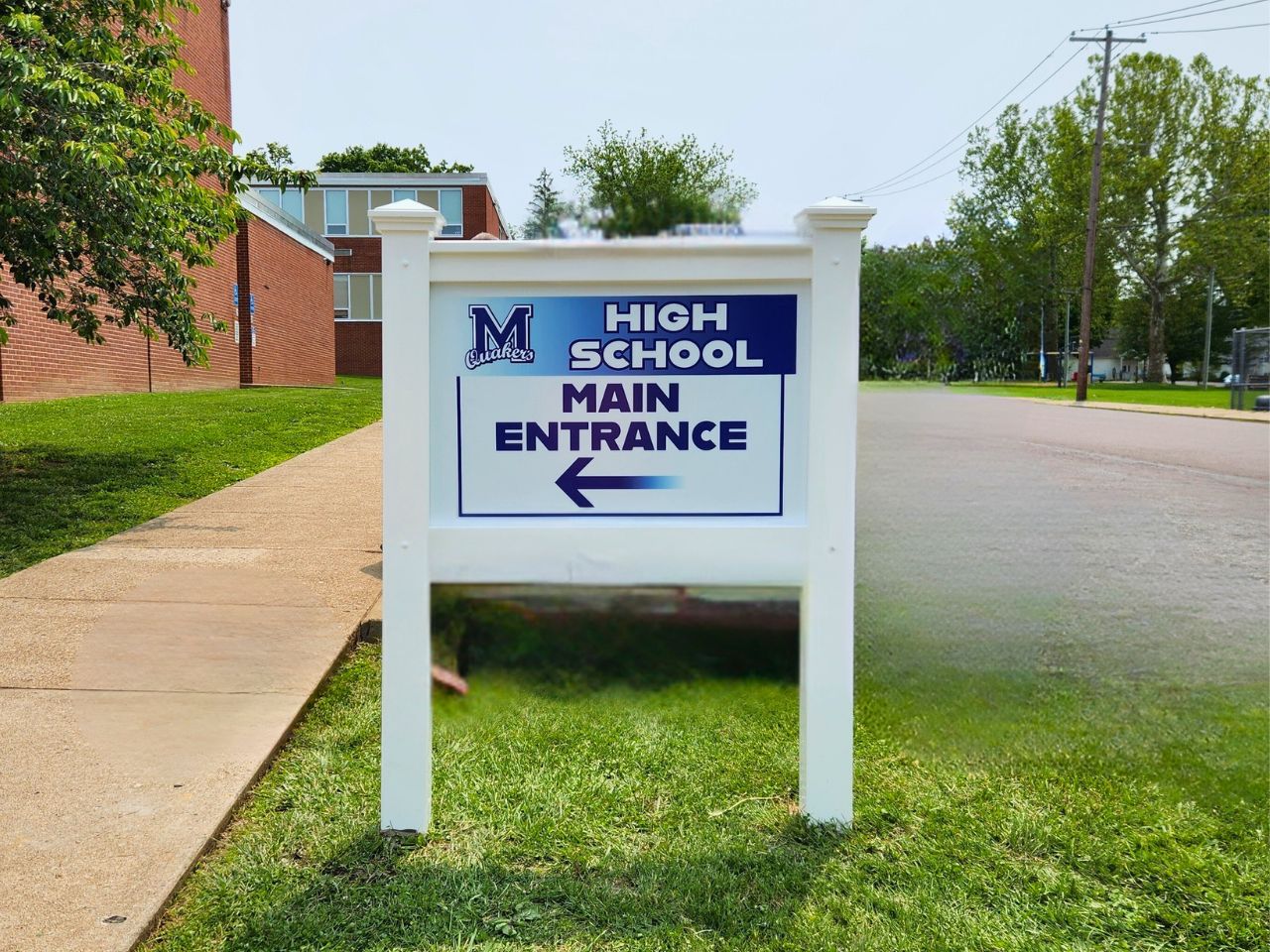 Exterior sign for Millville High School pointing in the direction of the school.